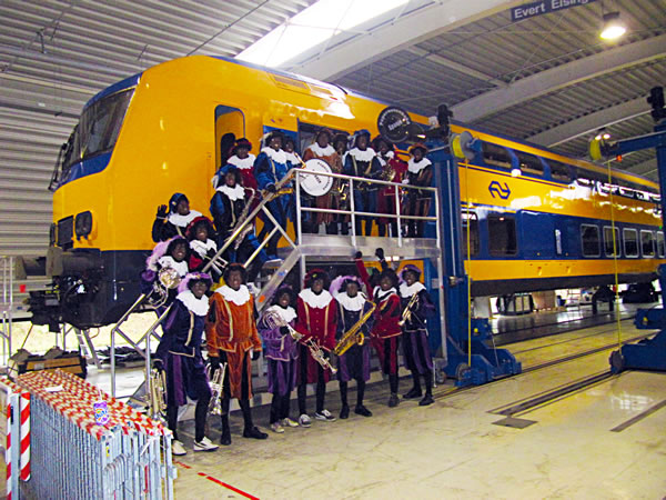 Groepsfoto van de Pietenband voor de trein van NS bij NedTrain